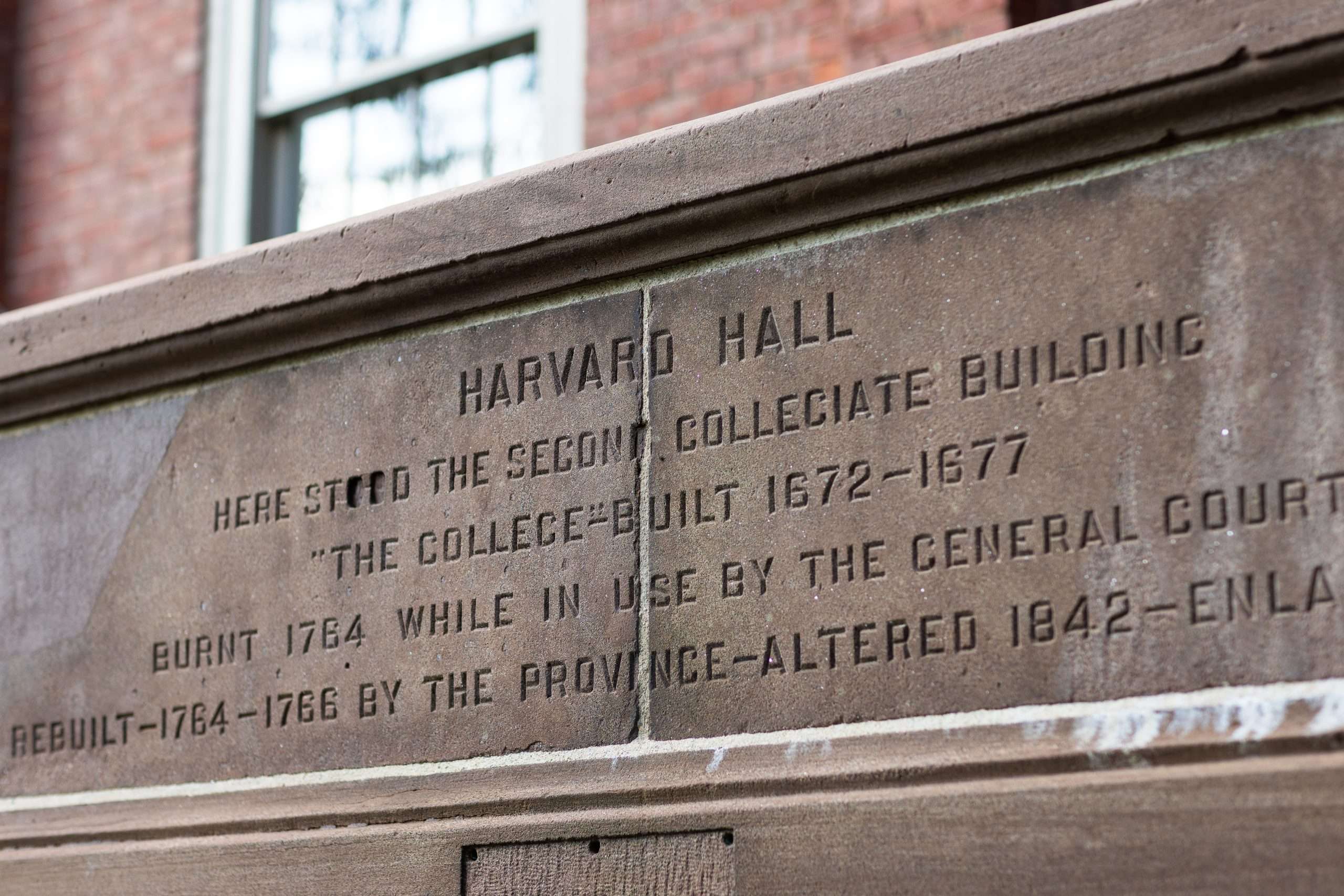 An inscription in stone is featured outside of Harvard Hall at Harvard University.
