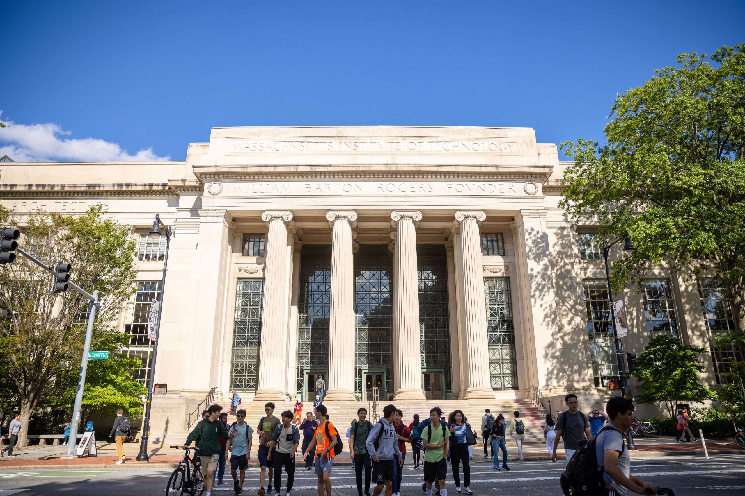 Students walk in front of a pillared building at the Massachusetts Institute of Technology