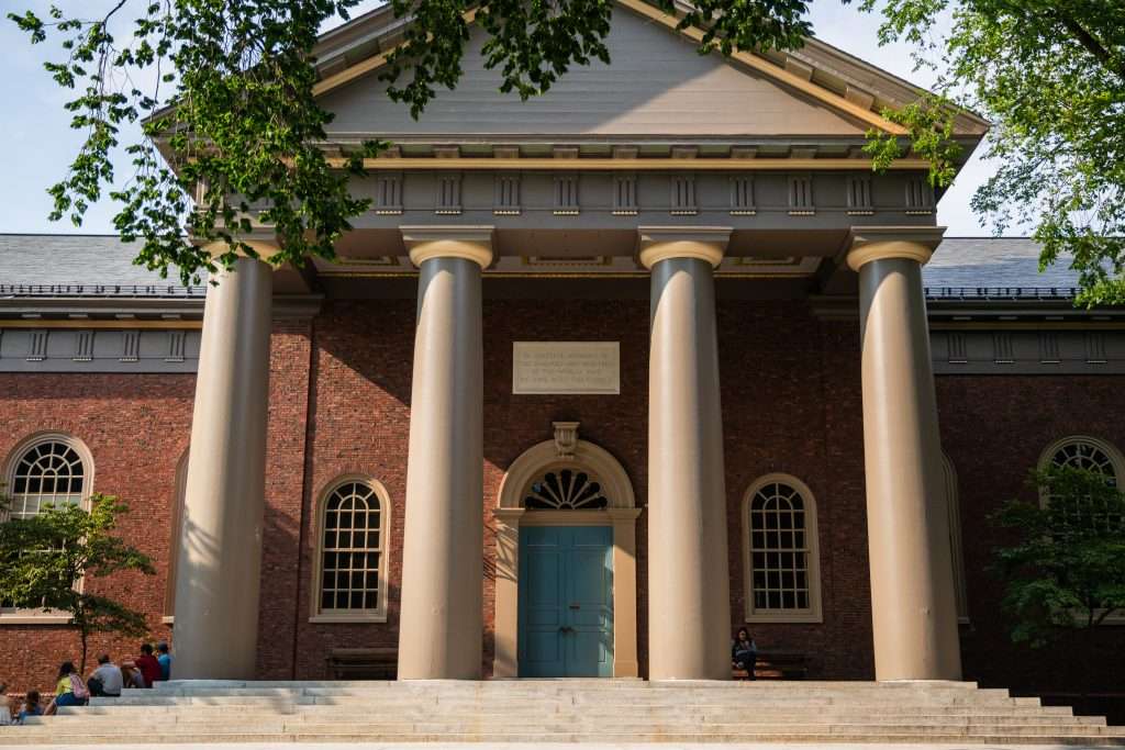 A columned building with blue doors is featured at Harvard University