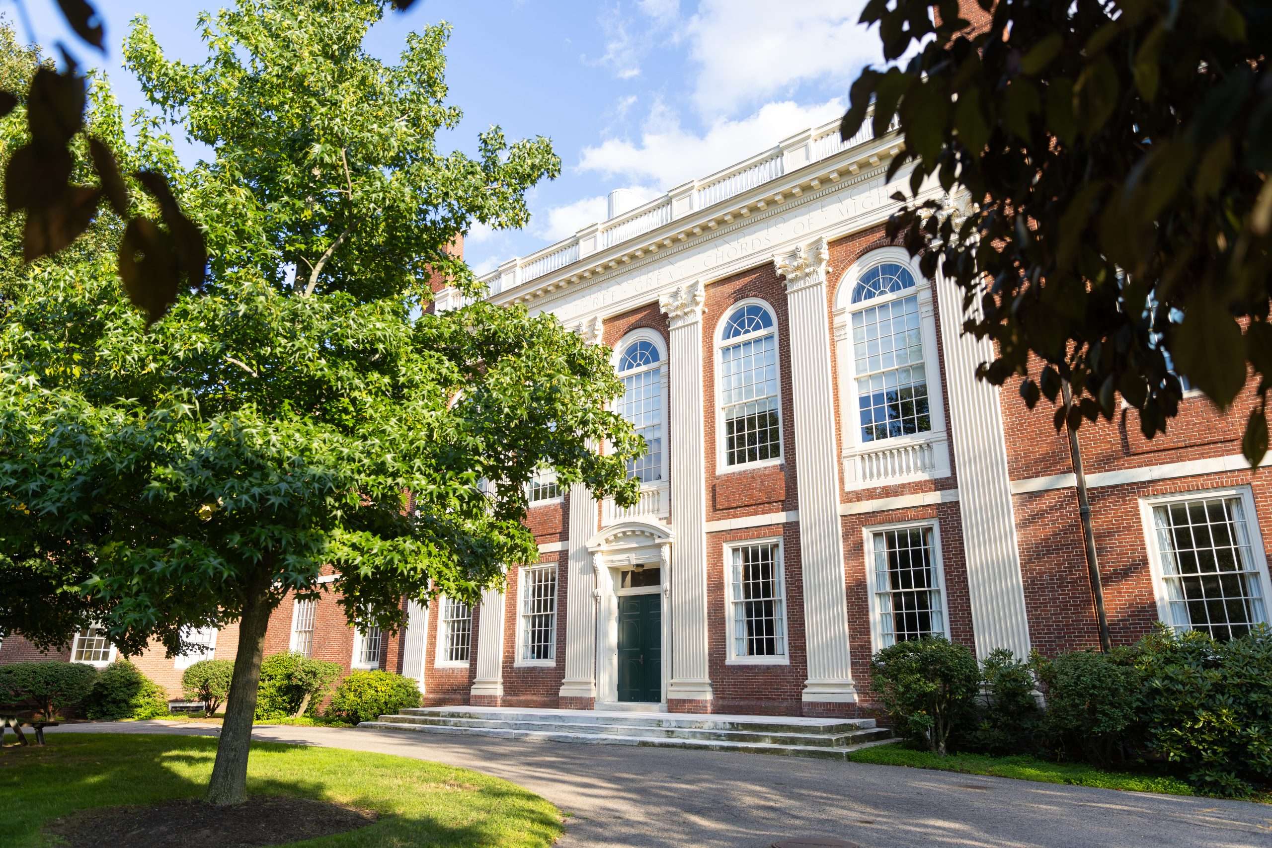 A brick building with a green door is featured at Harvard University.