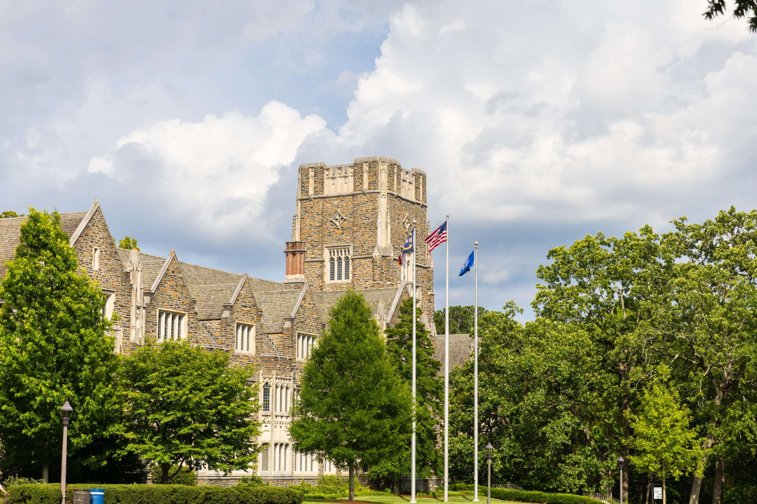 The flagpoles are featured in front of gothic architecture at Duke University.