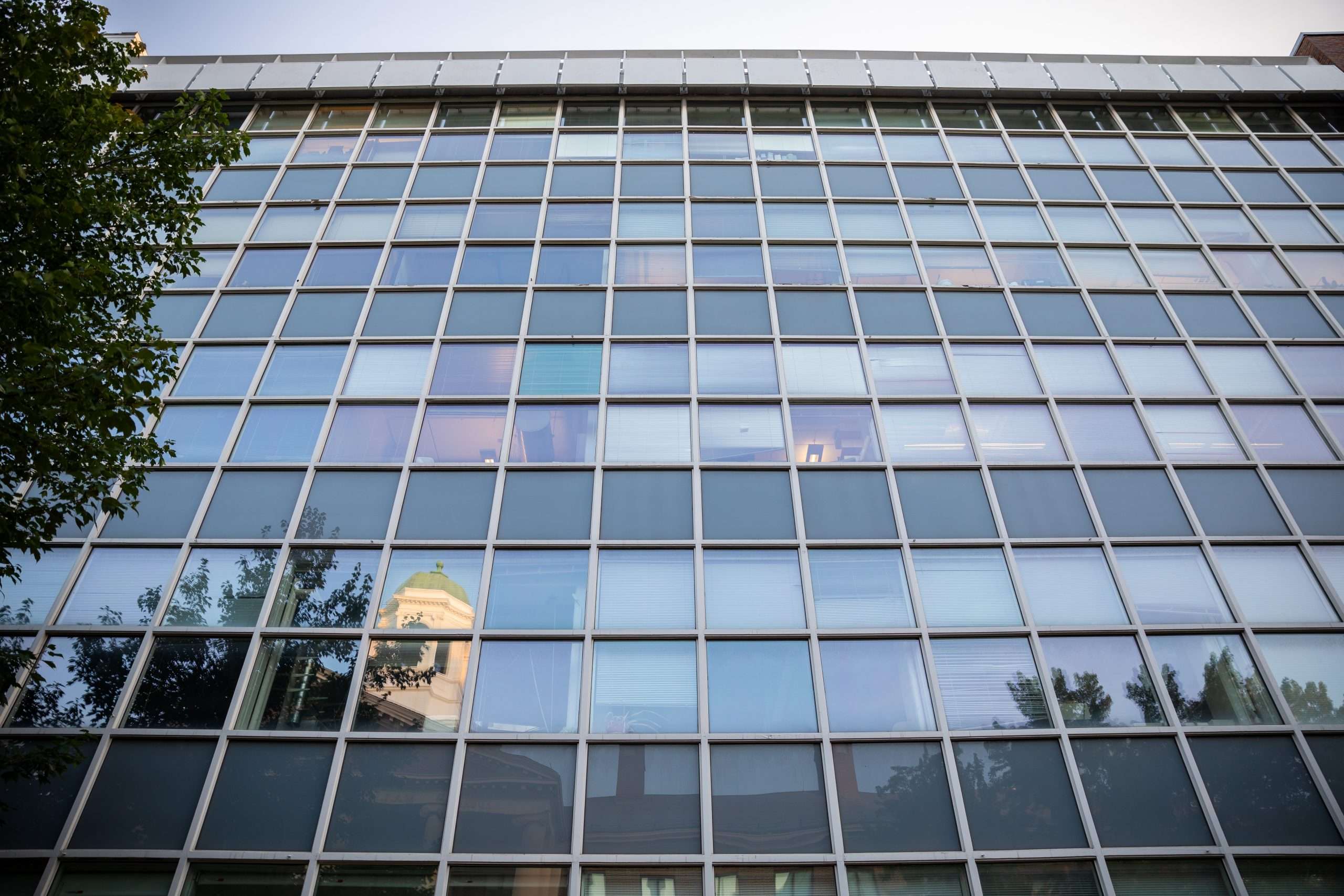 A view of a glass building from down below at Harvard University.