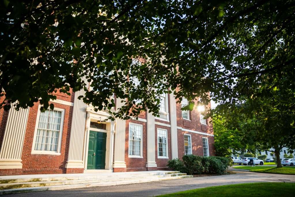 A brick building with a green door is featured at Harvard University.