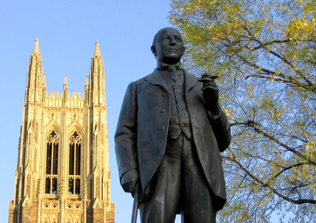 A bronze statue of James B. Duke sits in front of Duke Chapel.