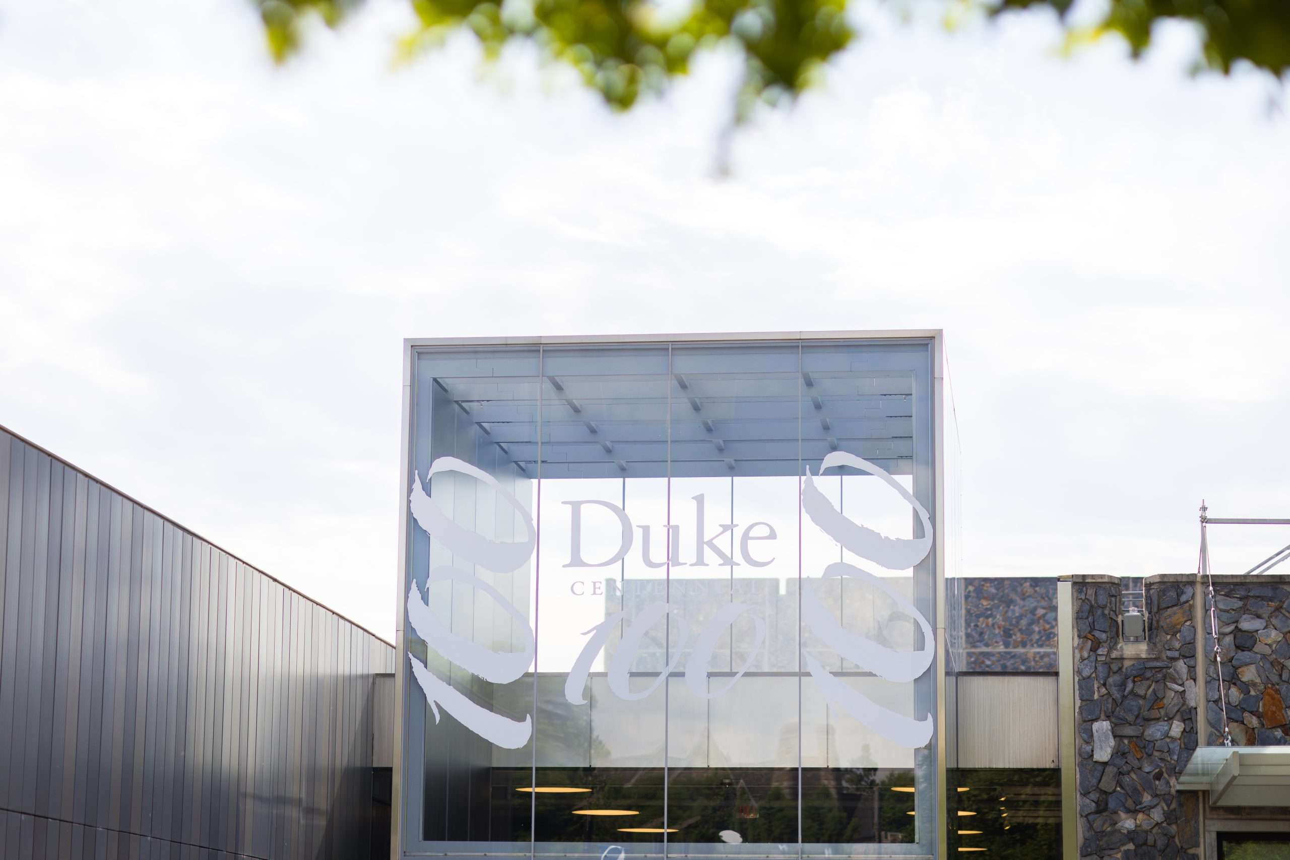 A glass facade with messaging commemorating Duke's 100th anniversary is featured.