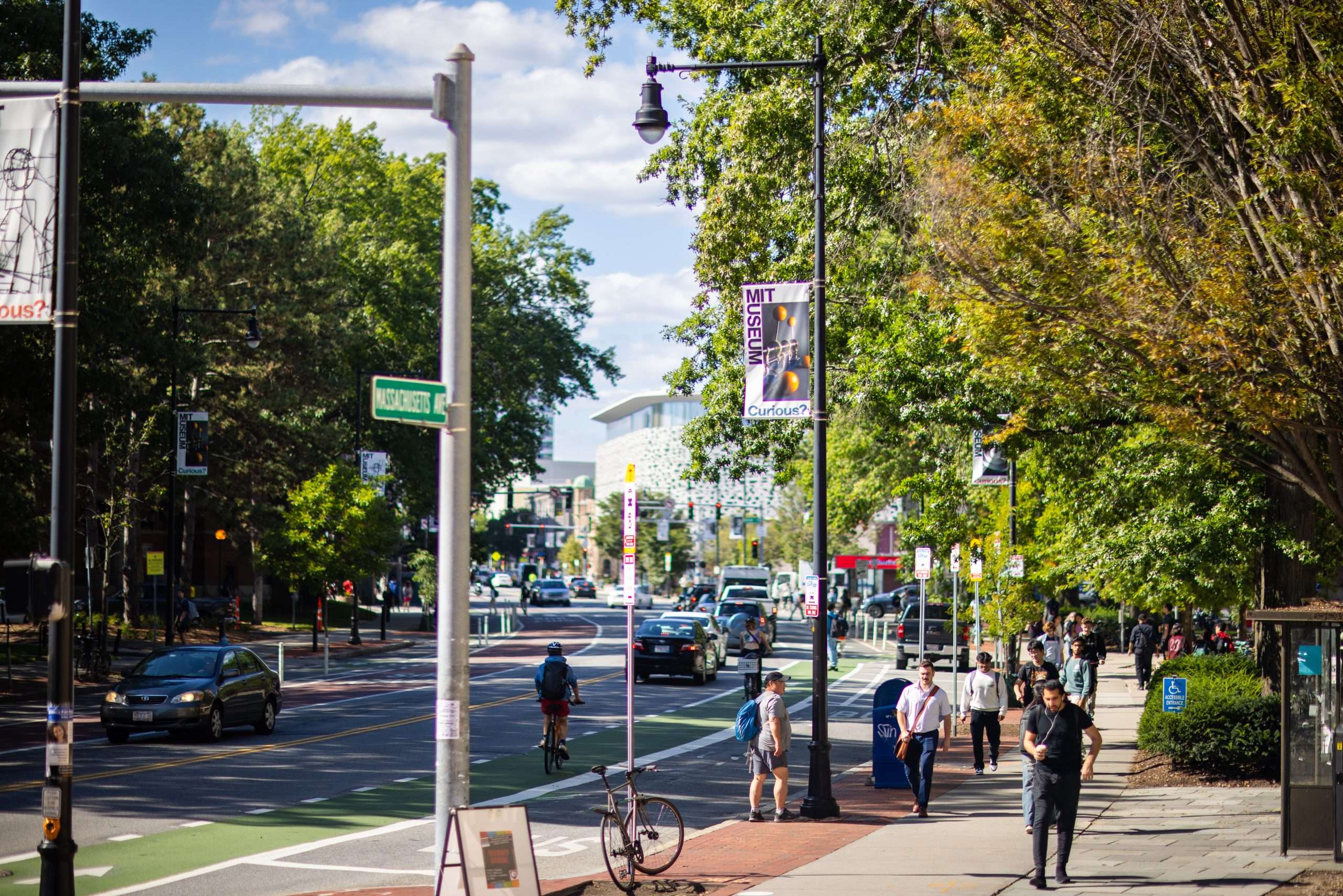 People walk and bike along Massachusetts Avenue at MIT.
