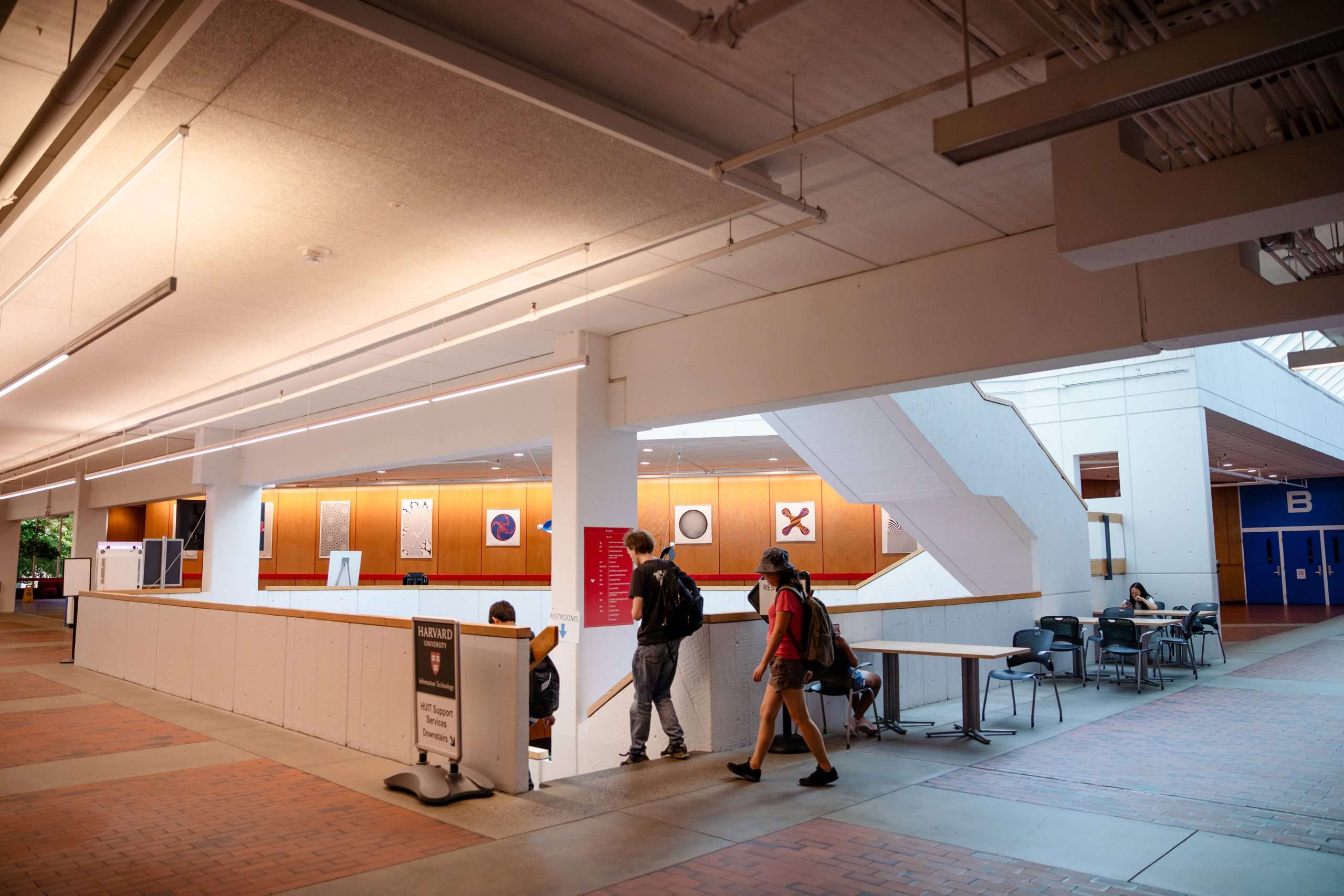 Students descend a staircase inside a Harvard University building.