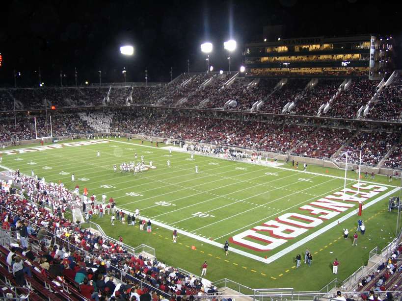 Fans attend an evening Stanford football game under the lights at Stanford's football field.