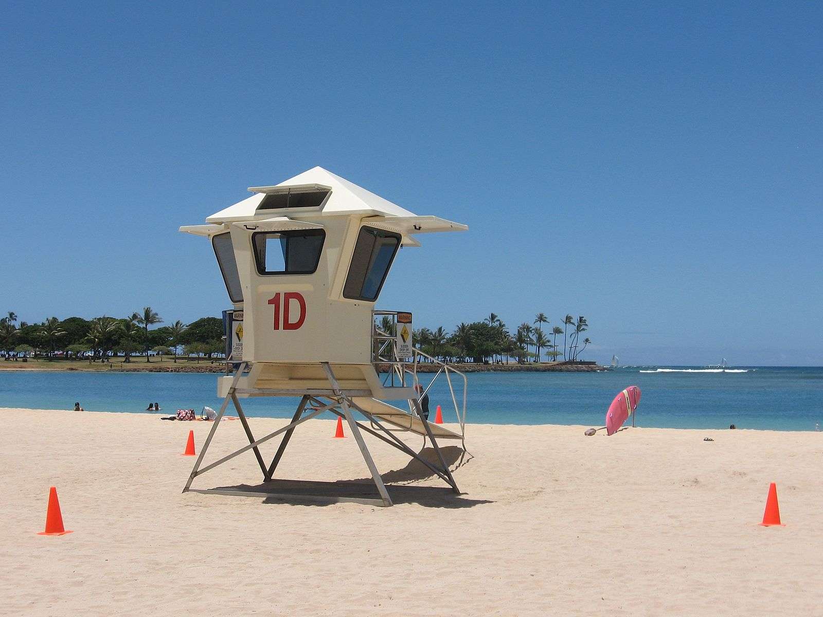 A lifeguard tower is featured on a beach.
