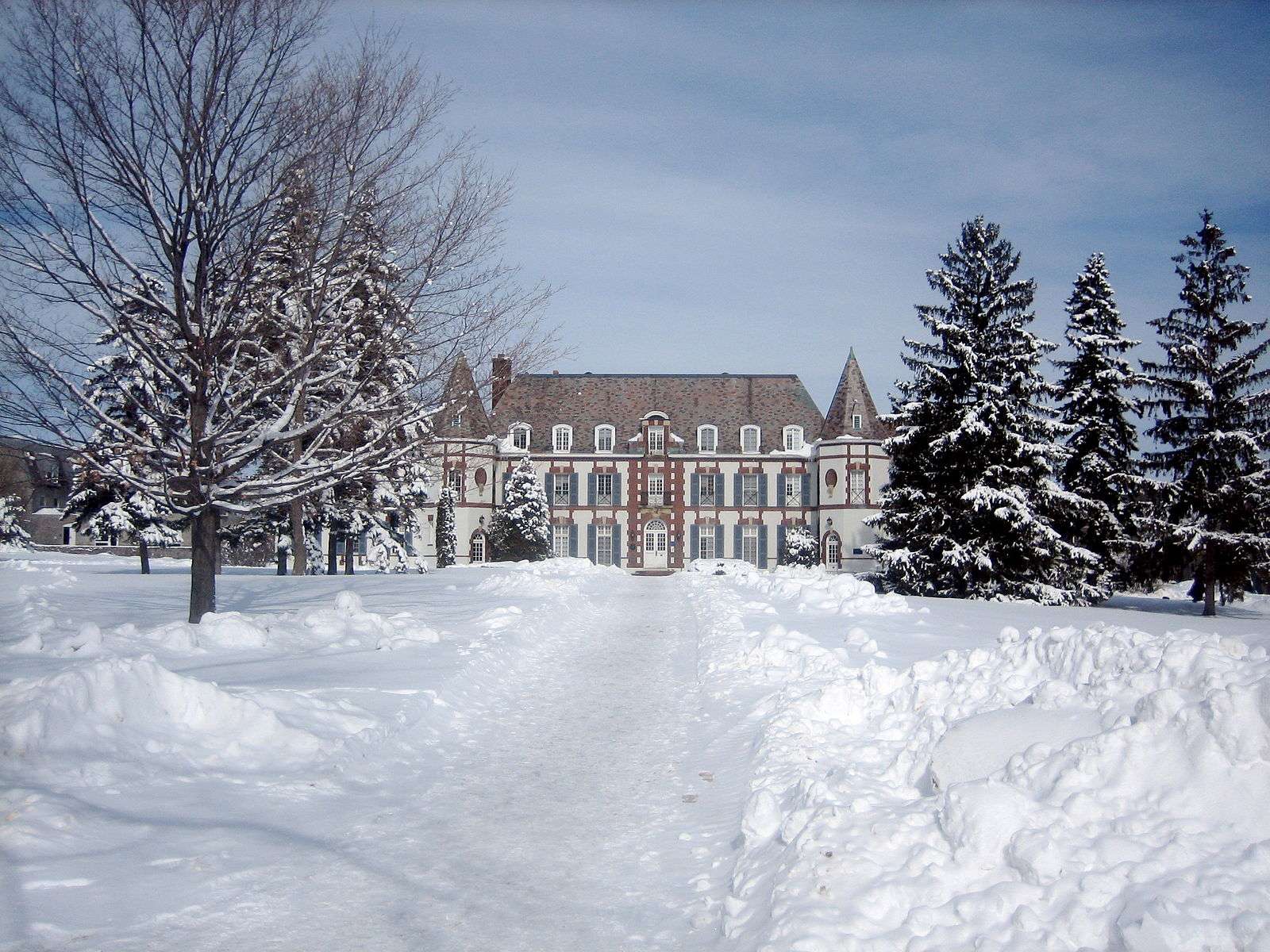 Le Chateau is featured behind a lawn covered in snow at Middlebury College.