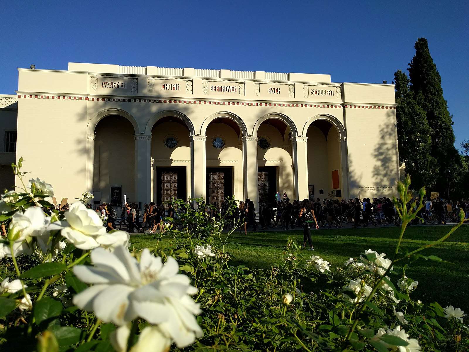 Students walk in front of Bridges Auditorium at Pomona College.