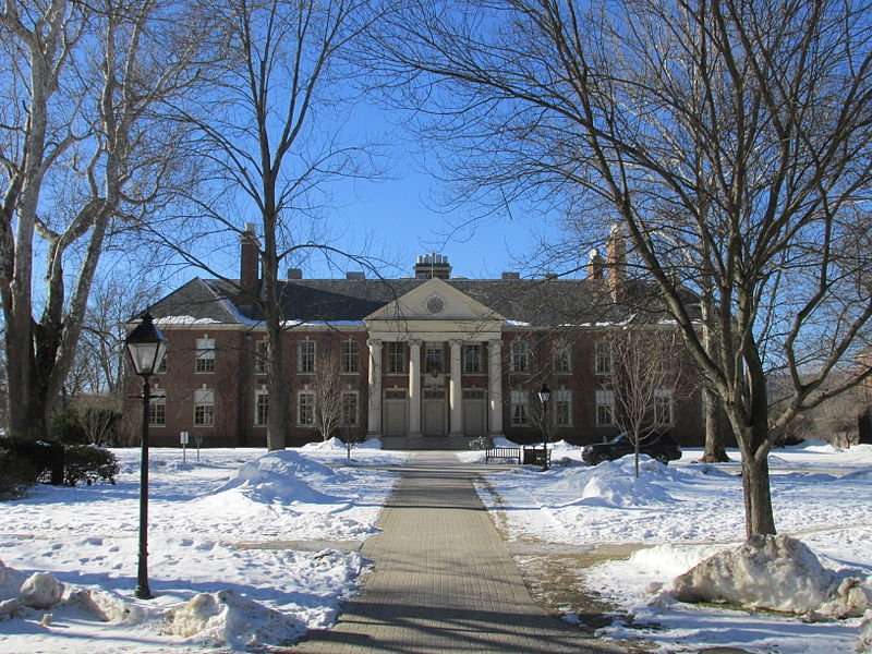 This is an image of a an Andover Academy building beyond a lawn covered in snow.