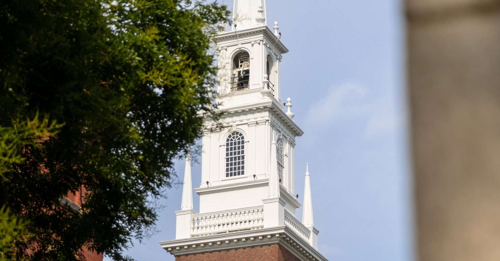 The steeple of a college chapel is seen from afar.