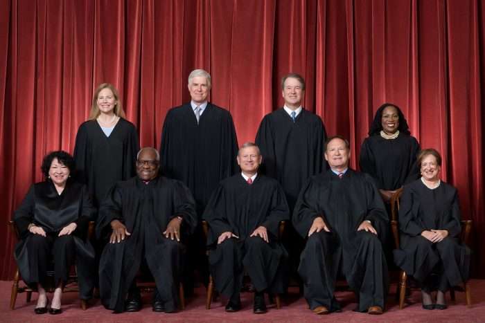 A portrait of the nine justices of the United States Supreme Court in 2022 in front of a red curtain.
