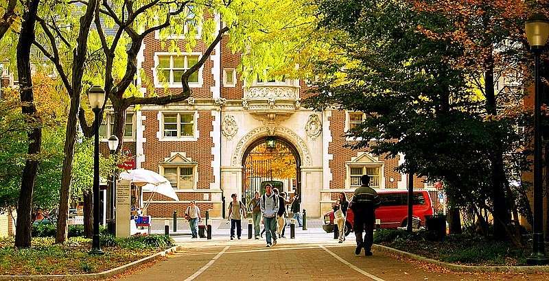 Students walk under an arch at the University of Pennsylvania.